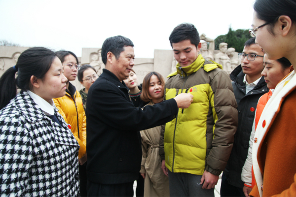 图为教科院党委书记周友士为学生党员佩戴党徽。记者 戴云 摄.jpg 图为教科院党委书记周友士为学生党员佩戴党徽。记者 戴云 摄.jpg